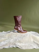 Botas de caña media de cuero marrón oscuro, con taco cuadrado forrado con estampado de serpiente y cierre lateral.