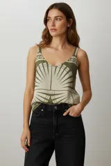 Top de viscosa ajustado al cuerpo, con escote profundo en V y detalle de argolla metálica en el centro del busto. Presenta un estampado geométrico en tonos verde oliva y beige claro.