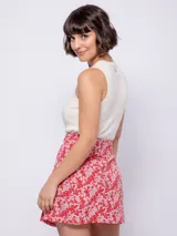 Falda corta con estampado floral en tonos verde lima y blanco, con cintura elástica y corte asimétrico en el ruedo.