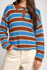Sweater de punto con diseño de rayas horizontales en color marrón y azul. Presenta cuello tipo polo con cierre frontal de tres botones y mangas largas con puños acanalados. Posee un corte oversize.