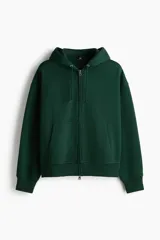 Campera con capucha de tejido pesado de mezcla de algodón con interior cepillado suave. Presenta hombros caídos, capucha forrada con cordón de ajuste, cierre frontal y bolsillos tipo canguro. Cuenta con puños y bajo acanalados, con un corte oversized.