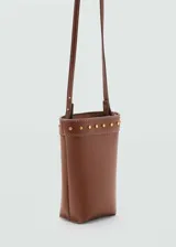 Funda para celular tipo bandolera de color marrón, confeccionada en efecto piel con detalle de tachuelas metálicas doradas en la parte superior y asa larga ajustable.