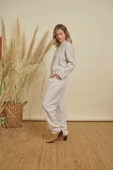 Pantalon de vestir color beige, de corte recto y tiro medio. Presenta pinzas frontales, bolsillos laterales y cintura con elástico en la parte posterior.