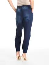 Pantalón tipo jogger de denim azul con efecto lavado. Presenta cintura elástica con cordón ajustable, bolsillos laterales y traseros, y puños elásticos en los tobillos.
