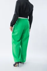 Pantalón de corte recto y tiro alto en color verde vibrante. Presenta una cinturilla elástica en contraste de color blanco, bolsillos laterales funcionales y una caída fluida.