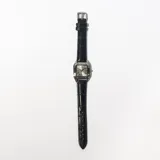 Reloj de pulsera con caja cuadrada plateada y correa de cuero negra con textura.
