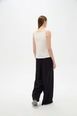 Top de viscosa color blanco con tirantes finos, cuello a la base y cierre frontal con botones. Presenta bolsillos appliqués con solapa en la parte inferior y diseño al cuerpo.