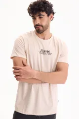Remera de algodón color beige con diseño de estampado tipográfico en el pecho, de corte regular fit y manga corta.