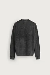 Sweater relaxed fit de canalé, color negro con efecto lavado, cuello redondo y manga larga con acabados en rib.