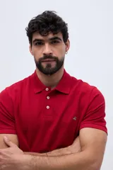 Remera polo verde militar de algodón pima, con cuello y puños acanalados, cierre frontal de tres botones y pequeño bordado de ave en el pecho.