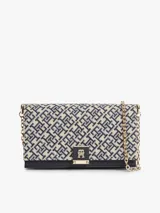 Cartera cruzada Tommy Hilfiger con diseño jacquard en tonos azul y beige, solapa con detalle de cuero sintético negro en la base y cierre con broche metálico dorado con monograma de la marca. Incluye correa de cadena dorada.
