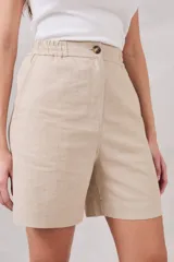 Bermuda color beige de lino y viscosa, tiro medio, corte recto y largo a la rodilla.
