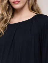 Blusa de modal y elastano color blanco, de silueta holgada, escote redondo amplio con elástico interno fruncido y mangas largas fluidas con puños ajustados.