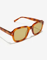 Lentes de sol unisex con armazón de acetato en tono carey y cristales amarillos. Presentan un diseño de marco cuadrado con detalles metálicos en las esquinas y la firma de Manuel Turizo en el interior de la patilla.