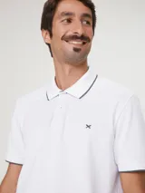 Chomba de manga corta color negro con cuello y tapeta interior en color gris claro. Presenta un pequeño bordado en el pecho y detalles de ribete en gris en el cuello y las mangas.