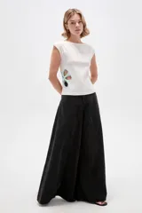 Remera de poliéster color blanco, de corte ajustado, con cuello bote, mangas sisa y detalles de aberturas (cut-out) en los costados con apliques florales en tono celeste.