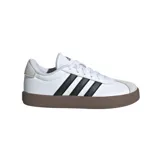 Zapatillas Adidas VL Court 3.0, de cuero blanco con las tres tiras clásicas en negro, detalles en gamuza gris en la puntera y el talón, y suela marrón.