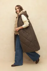 Chaleco largo marrón capitoneado con capucha, cierre frontal y bolsillos laterales. Forro interno de satén con estampado animal print.