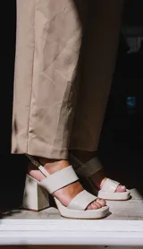 Sandalias de plataforma color crema, con tiras anchas de charol y hebilla ajustable en el tobillo.