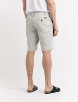 Bermuda de gabardina color verde medio, corte recto y largo a la rodilla.