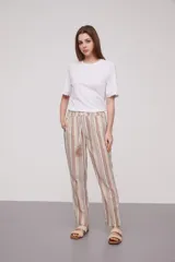Pantalón babucha celeste con rayas verticales blancas, cintura elástica con cordón y detalle de borlas.