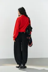 Jeans negro de tiro medio con corte balloon fit, diseño de cinco bolsillos y bajo acabado en puño con abertura y botón.