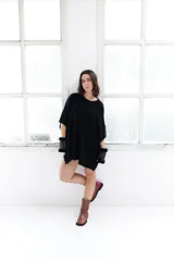 Poncho celeste de tejido de punto con cuello redondo y terminación desflecada.