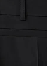 Pantalón de tiro bajo y diseño acampanado color negro, con trabillas para cinturón y bolsillos traseros ribeteados, confeccionado en mezcla de algodón elástico.
