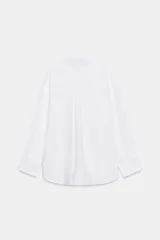 Camisa básica de algodón con cuello solapa, escote en pico y cierre frontal con botones. Presenta mangas largas con puños abotonados y bajo redondeado.