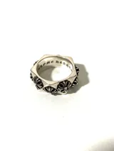 Anillo plateado con forma geométrica y diseño de flores.