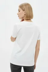 Remera de manga corta color azul marino con cuello redondo y estampado frontal de una flor en tonos celestes y blancos.