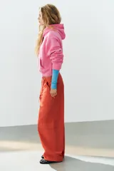 Pantalón cargo oversize de tiro medio color rojo, con bolsillos laterales y de plastrón, y lazadas ajustables en la cintura.