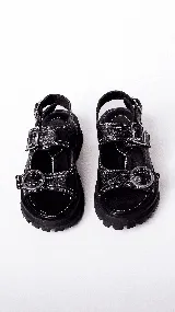 Sandalias de mujer con plataforma gruesa y dentada de color negro. La capellada presenta un estampado de piel de serpiente en tonos beige y marrón, con dos tiras ajustables con hebillas de cuero marrón.