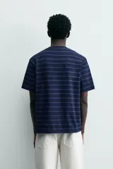 Camiseta de hombre regular fit, color azul marino con rayas horizontales en azul más claro. Tiene cuello redondo y manga corta, con un efecto lavado.