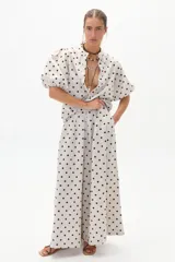 Pantalón palazzo de lino color crema con lunares negros, de tiro alto y corte amplio.