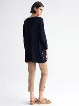 Sweater largo azul marino de tejido de punto, con cuello redondo, mangas 3/4, bolsillo lateral y botones decorativos en el ruedo.