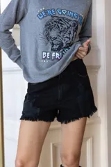 Short de jean negro de tiro alto con roturas en la pierna y ruedo desflecado.