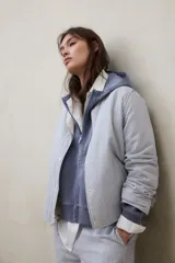 Chaqueta reversible de calce regular con diseño a rayas, cuello redondo, cierre frontal con broches y bolsillos laterales.
