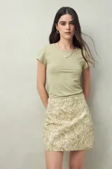 Minifalda de algodón con estampado botánico en tonos verde claro y beige, de corte recto.