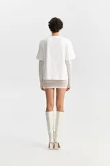 Camiseta blanca de manga corta con silueta holgada y cuello redondo.