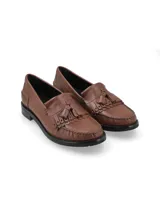Mocasín de cuero color marrón cognac con detalle de flecos y borlas en el empeine, costuras pespunteadas y suela plana con pequeño tacón.