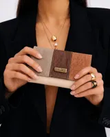 Billetera de cuero Valdez, de diseño estructurado y diseño tricolor en tonos beige, marrón oscuro y suela, con solapa frontal texturizada y placa metálica con el logo de la marca.
