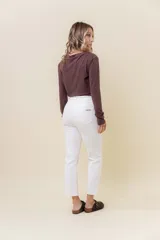 Pantalón de jean negro, corte recto, tiro medio-alto y largo al tobillo.