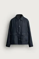 Sobrecamisa relaxed fit azul marino confeccionada en tejido de lino, con cuello solapa, manga larga con puño abotonado, bolsillos de plastrón en la cadera y cierre frontal de botones.