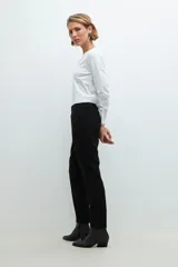 Pantalón negro de vestir, corte slim, con cintura elástica y bolsillos laterales.