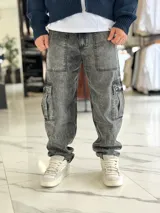 Pantalón cargo de jean gris con efecto acid wash, corte holgado y bolsillos utilitarios en los laterales y muslos.
