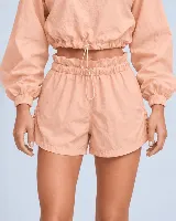 Short tipo clochard color salmón, con cintura elastizada ajustable mediante cordón, bolsillos laterales y detalles fruncidos con cordón ajustable en los laterales.