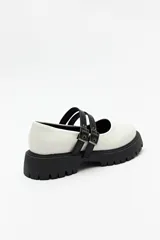 Guillerminas negras de cuero sintético charolado, con plataforma chunky y doble tira ajustable con hebillas metálicas.