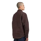 Chaqueta tipo camisa (shirt jacket) Carhartt WIP modelo Bellamy, confeccionada en tejido tweed multicolor con predominancia de tonos marrones, negros y rojizos. Presenta cuello camisero, cierre frontal de cremallera y un bolsillo de parche con etiqueta tejida de la marca en el pecho.