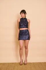Top corto sin mangas con cuello alto, confeccionado completamente con lentejuelas brillantes en tono azul marino.
